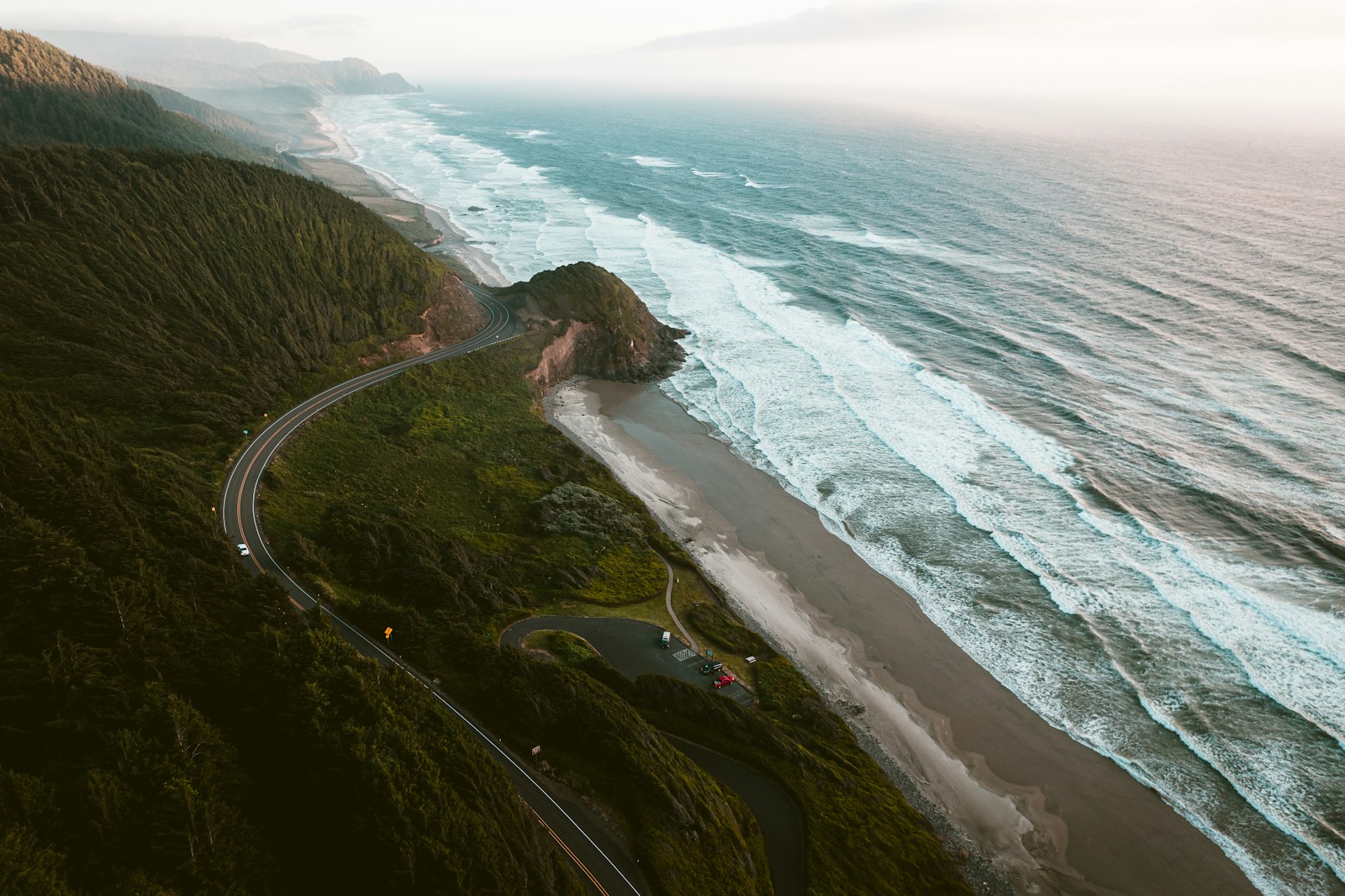 Aerial view of Highway 101 winding along the Oregon coast with old-growth forest